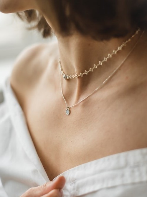 Woman wearing two minimalistic necklaces